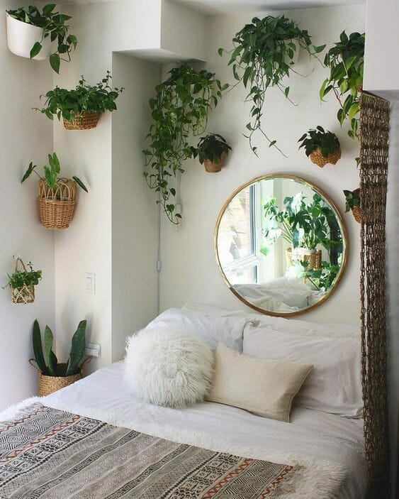 rośliny w sypialni i lustro nad łóżkiem