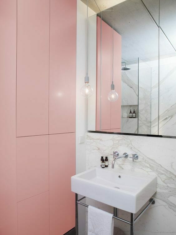 łazienka z szarym marmurem i różowymi szafkami