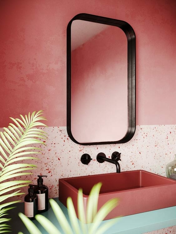 różowa nowoczesna łazienka z lustrem z czarną ramą i czarną baterią