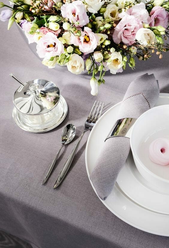 nakrycie stołu w kolorze szarym ze srebrnymi dodatkami i białym talerzem