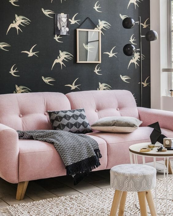 różowa kanapa na tle czarnej tapety